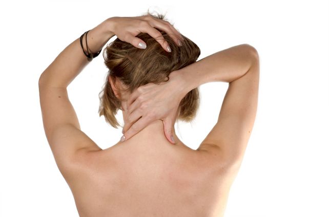 Exhausted girl making self-massage of her neck isolated