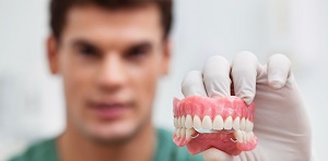 Male practitioner holding dental mold