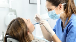 Dentist examining patient teeth at office